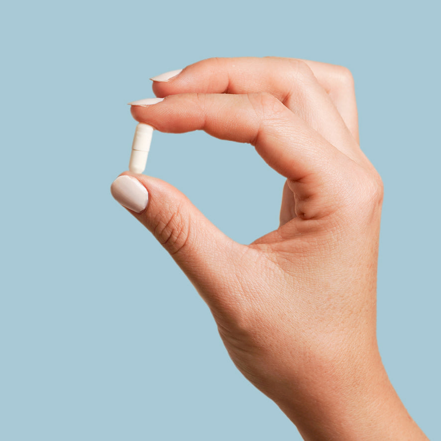 Hand holding a Qi601 capsule